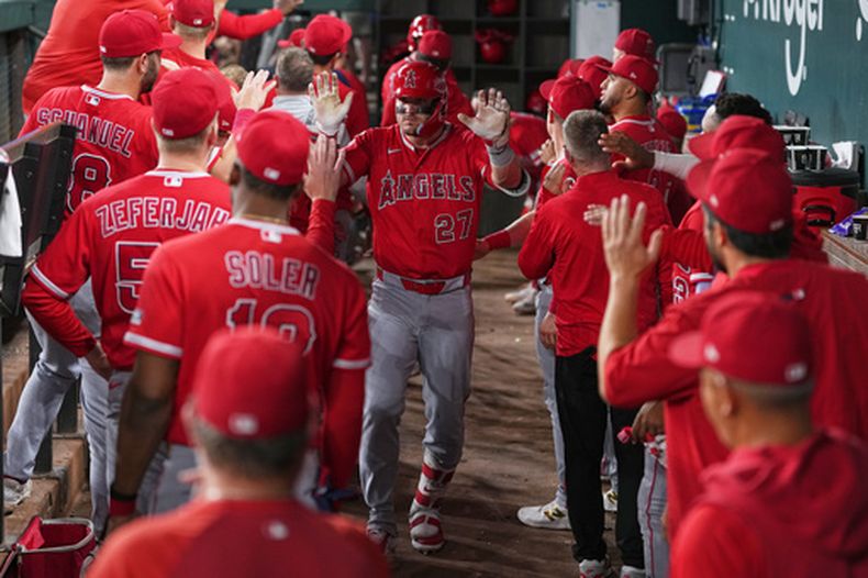 Mike Trout, bateador designado de los Angelinos de Los Ángeles, es felicitado en el dugout después de batear un jonrón de dos carreras contra los Rangers de Texas durante la octava entrada del juego de béisbol de Grandes Ligas del miércoles 8 de julio de 2026, en Arlington, Texas. (AP Foto/Julio Cortez)