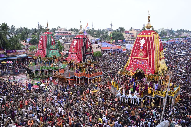 Devotos hindúes caminan en una procesión que acompaña a tres grandes carrozas con imágenes de deidades, en Puri, India, el sábado 28 de junio de 2025. (AP Foto)