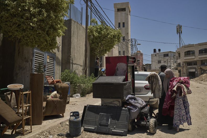 Varios palestinos reúnen sus pertenencias antes de que sus viviendas sean demolidas por las fuerzas israelíes en el campamento de refugiados de Tulkarem en Cisjordania, el miércoles 2 de julio de 2025. (AP Foto/Leo Correa)