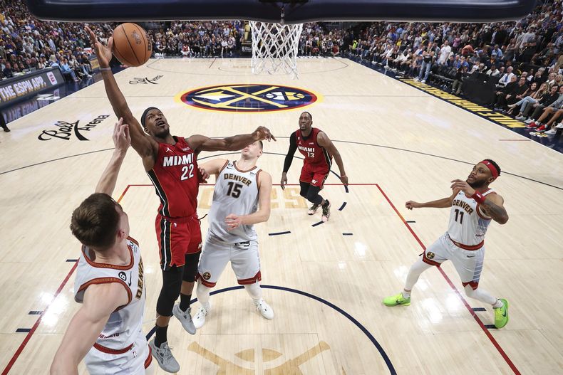 Jimmy Butler (22) del Heat de Miami Christian Braun de los Nuggets de Denver pugnan por un balón en el quinto de las Finales de la NBA, el lunes 12 de junio de 2023, en Denver. (Matthew Stockman/Pool Foto vía AP)