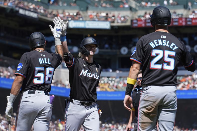 Kyle Stowers, centro, de los Marlins de Miami, celebra con Derek Hill (58) después de batear jonrón de tres carreras durante la quinta entrada del juego de béisbol en contra de los Gigantes de San Francisco, el domingo 1 de septiembre de 2024, en San Francisco. (AP Foto/Godofredo A. Vásquez)