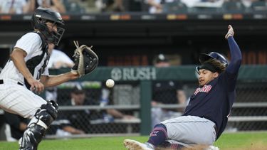 Josh Naylor, de los Guardianes de Cleveland, se desliza para anotar frente al cátcher mexicano Seby Zavala, de los Medias Blancas de Chicago, el jueves 27 de julio de 2023 (AP Foto/Erin Hooley)