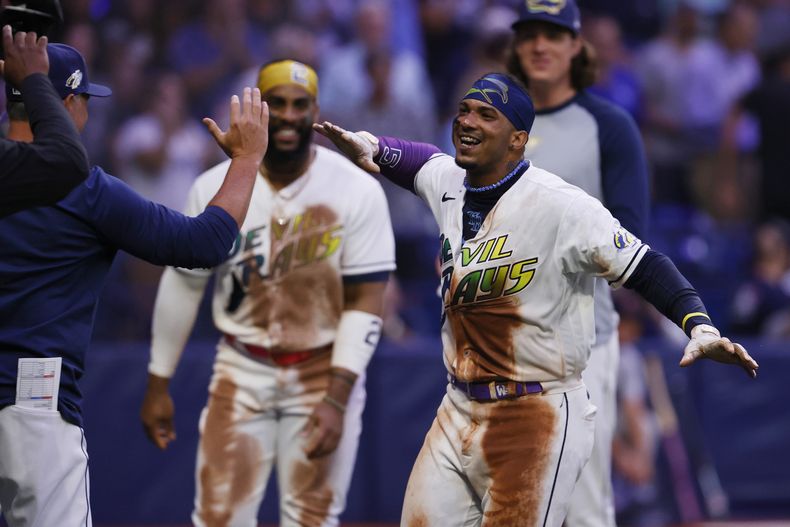 Wander Franco, derecha, de los Rays de Tampa Bay, celebra con el manager Kevin Cash después de dejar tendidos a los Guardianes de Cleveland con un cuadrangular en la parte baja de la novena entrada, en el juego de béisbol del viernes 11 de agosto de 2023, en San Petersburgo, Florida. (AP Foto/Scott Audette)