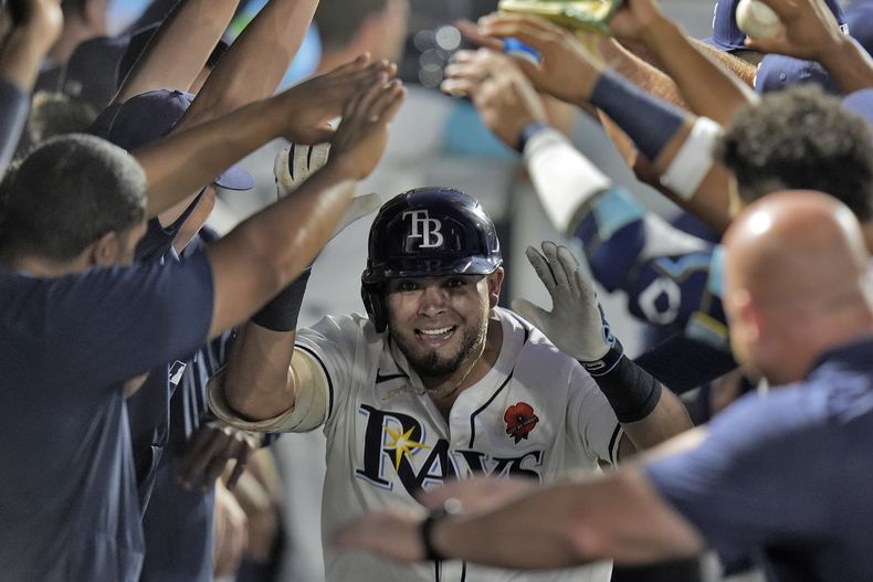 Jonathan Aranda, de los Rays de Tampa Bay, celebra en el dugout después de disparar un jonrón de tres carreras frente al relevista de los Mellizos de Minnesota, Brock Stewart, durante la sexta entrada del juego de béisbol de Grandes Ligas, el lunes 26 de mayo de 2025, en Tampa, Florida. (AP Foto/Chris OMeara)