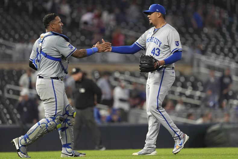 El receptor de los Reales de Kansas City, Salvador Pérez, a la izquierda, y el lanzador relevista Carlos Hernández se dan la mano después de la victoria por 6-1 contra los Mellizos de Minnesota en el juego de béisbol el miércoles 29 de mayo de 2024, en Minneapolis. (AP Foto/Abbie Parr)