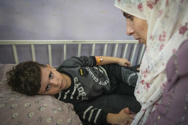 Nima al-Askari, derecha, cuida a su hijo Qusay al-Askari, de 4 años, en Deir al-Ballah, Franja de Gaza, el 16 de noviembre de 2024. (AP Foto/Abdel Kareem Hana)