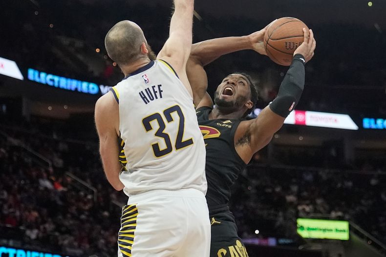 Donovan Mitchell, escolta de los Cavaliers de Cleveland, a la derecha, busca lanzar mientras el pívot de los Pacers de Indiana, Jay Huff (32), defiende en la segunda mitad de un juego de baloncesto de la Copa NBA el viernes 21 de noviembre de 2025, en Cleveland. (AP Photo/Sue Ogrocki)