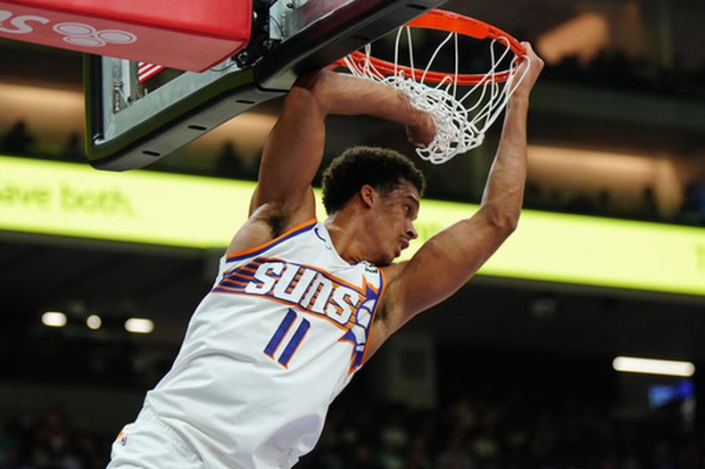 Oso Ighodaro, de los Suns de Phoenix, cuelga del aro durante el partido ante los Kings de Sacramento, el martes 3 de marzo de 2026 (AP Foto/Alan Greth)