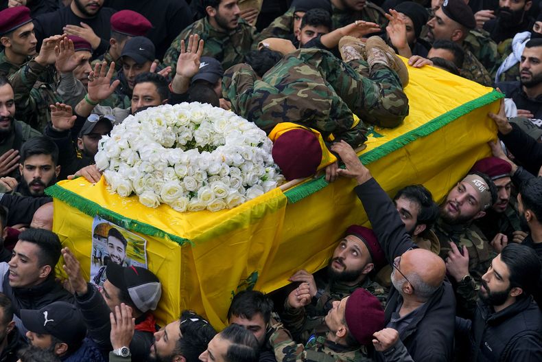 Hussein, hermano del combatiente de Hezbollah Ali Hassan al-Atat, muerto durante un ataque israelí, se arroja sobre el ataúd de su hermano durante una procesión fúnebre en Dahiyeh, al sur de Beirut, 7 de diciembre de 2023 (AP Foto/Bilal Hussein)