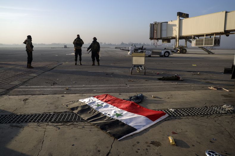 Combatientes de la oposición siria en el aeropuerto militar en Hama, en Siria, el 6 de diciembre de 2024, poco antes de la caída del gobierno. (AP Foto/Ghaith Alsayed)
