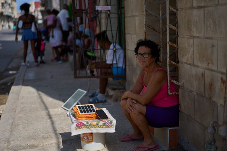 Una mujer carga una batería utilizando un pequeño panel solar en la calle durante un apagón en La Habana, Cuba, el viernes 18 de septiembre de 2026. (Foto AP/Ramón Espinosa)
