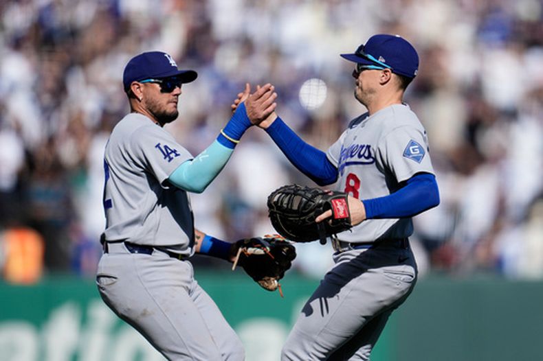 El tercera base de los Dodgers de Los Ángeles Miguel Rojas celebra con el primera base Enrique Hernández tras la victoria ante los Gigantes de San Francisco el sábado 26 de septiembre del 2026. (AP Foto/Jeff Chiu)