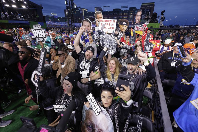 Aficionados de los Raiders de Las Vegas celebran durante la primera ronda del draft de la NFL en Green Bay, Wisconsin el jueves 24 de abril del 2025. (AP Foto/Matt Ludtke)