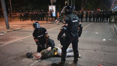 Agentes de la policía antimotines detienen a un hombre tras cargar contra manifestantes al final de una protesta antigubernamental que exigía la convocatoria de elecciones anticipadas en medio de una oleada de movilizaciones contra la corrupción que han sacudido al gobierno del presidente Aleksandar Vucic, en Belgrado, Serbia, el 28 de junio de 2025. (AP Foto/Darko Vojinovic)