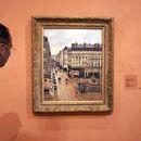 ARCHIVO - Un visitante observa el cuadro impresionista titulado Rue St.-Honore, Apres-Midi, Effet de Pluie (Calle Saint-Honoré por la tarde, efecto de lluvia) pintado en 1897 por Camille Pissarro, expuesto en el Museo Thyssen-Bornemisza el 12 de mayo de 2005, en Madrid. (AP Photo/Mariana Eliano, File)