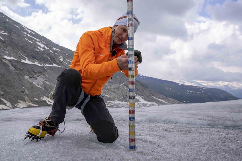 ARCHIVO - El observador de glaciares y director de la red suiza de medición Glamos, Matthias Huss, revisa el grosor del glaciar Rhone, cerca de Goms, Suiza, el viernes 16 de junio de 2023. (AP Foto/Matthias Schrader, Archivo)