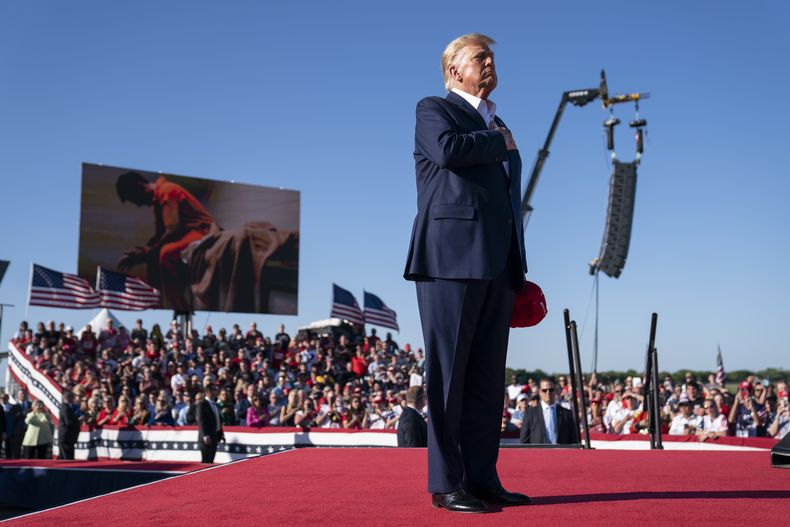 ARCHIVO - El expresidente Donald Trump permanece de pie mientras se interpreta la canción Justice for All (Justicia para todos) durante un mitin de su campaña por la nominación republicana a la presidencia, en el Aeropuerto Regional de Waco, el 25 de marzo de 2023, en Waco, Texas. (AP Foto/Evan Vucci)