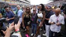 Serena Williams, Venus Williams posan con un aficionado de la F1 en la parrilla de salida antes del inicio del Gran Premio de Miami el domingo 7 de mayo dle 2023. (AP Foto/Rebecca Blackwell)