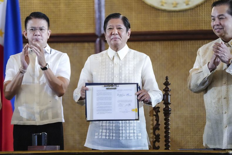 En esta fotografía proporcionada por la oficina de prensa presidencial de Filipinas, el presidente filipino Ferdinand Marcos Jr. (centro) sostiene un documento junto al presidente del Senado, Francis Escudero (izquierda), y el presidente de la Cámara de Representantes, Martin Romualdez, durante la promulgación de unas nuevas leyes marítimas, en el palacio presidencial de Malacanang, en Manila, Filipinas, el viernes 8 de noviembre de 2024. (Oficina de Prensa de la presidencia de Filipinas vía AP)