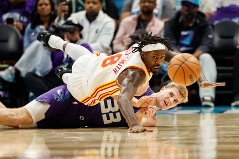 Dorian Finney-Smith, de los Hawks de Atlanta, disputa un balón con Liam McNeeley, de los Hornets de Charlotte, en el partido del viernes 23 de octubre de 2026 (AP Foto/Nell Redmond)