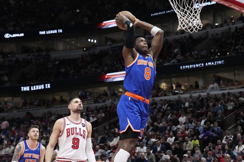 El alero de los Knicks de Nueva York OG Anunoby salta para clavar el balón mientras lo observa el pívot de los Bulls de Chicago Nikola Vucevic en el encuentro de la NBA del martes 9 de abril del 2024. (AP Foto/Nam Y. Huh)