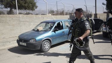 americateve | Un polic&iacute;a israel&iacute; camina junto a un autom&oacute;vil da&ntilde;ado en el patio de una escuela en la aldea de Jaloud, en Cisjordania, el mi&eacute;rcoles, 9 de octubre del 2013. Residentes dela aldea dijeron que colonos jud&iacute;os enmasca