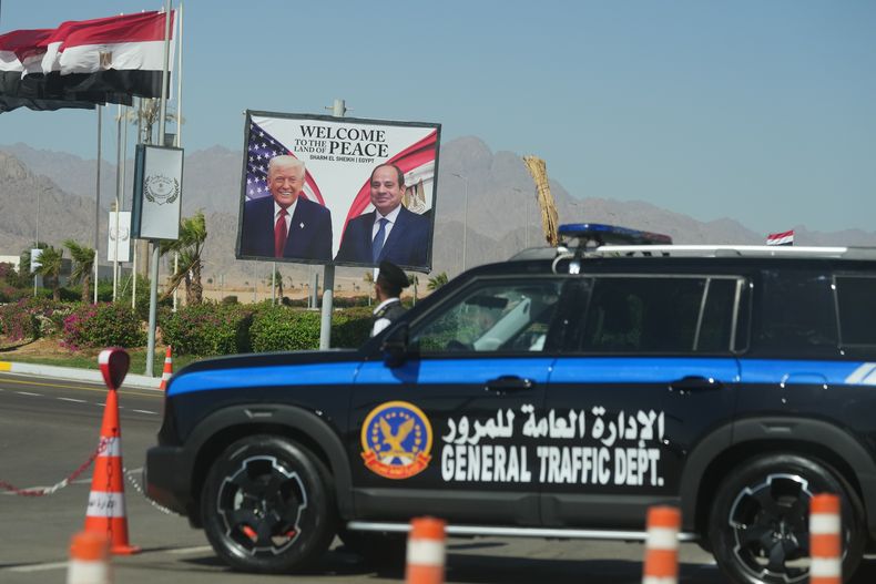 Un vehículo policial se ve ante un cartel que muestra al presidente de Egipto, Abdul Fatá el Sisi, y el presidente de Estados Unidos, Donald Trump, en la ciudad de Sharm el Sheij, en el mar Rojo, el lunes 13 de octubre de 2025. (AP Foto/Amr Nabil)