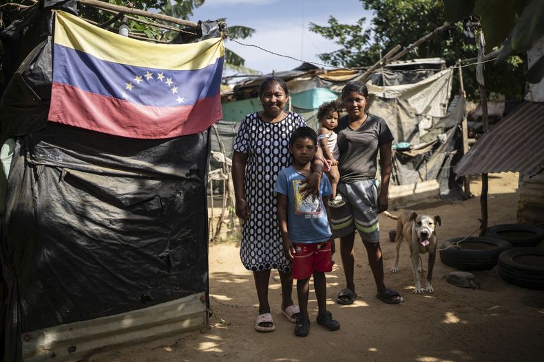Nelly Mengual, izquierda, posa con su hija Luciane Mengual y sus nietos en el barrio de Villa del Sur, en las afueras de Riohacha, Colombia, el martes 4 de febrero de 2025. (AP Foto/Ivan Valencia)
