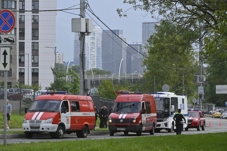 Vehículos policiales y de emergencias están estacionados al lado de los escombros de un dron caído cerca del terraplén Karamyshevskaya en Moscú, viernes 11 de agosto de 2023. (AP Foto)
