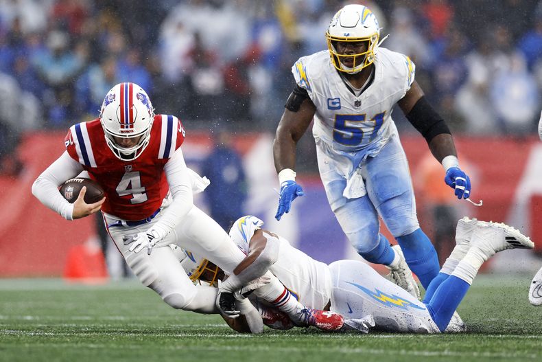 Bailey Zappe (4), quarterback de los Patriots de Nueva Inglaterra, es capturado por el linebacker Eric Kendricks (6), de los Chargers de Los Ángeles, durante la segunda mitad del juego de la NFL, el domingo 3 de diciembre de 2023, en Foxborough, Massachusets. (AP Foto/Michael Dwyer)