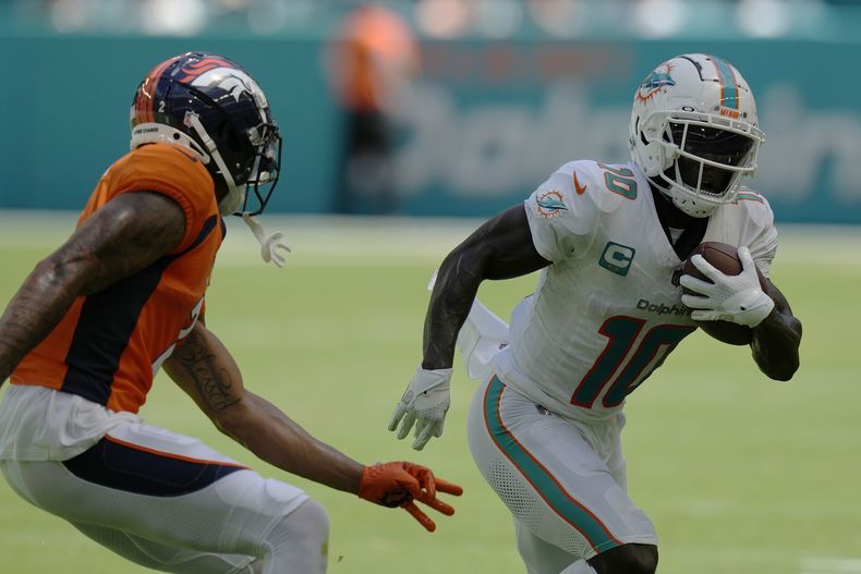 El receptor de los Dolphins de Miami Tyreek Hill corre con el balón frente al cornerback de los Broncos de Denver Pat Surtain en el encuentro del domingo 24 de septiembre del 2023. (AP Foto/Rebecca Blackwell)