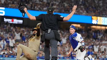 Fernando Tatis Jr., izquierda, observa la decisión del umpire después de anotar con un elevado de sacrificio de Manny Machado después de que el receptor de los Dodgers de Los Ángeles, Will Smith, no lo pudiera retirar en la quinta entrada del juego de béisbol de Grandes Ligas, el miércoles 23 de septiembre de 2026, en Los Ángeles. (AP Foto/Mark J. Terrill)