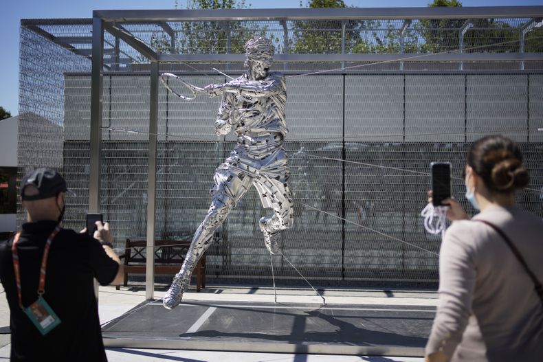 ARCHIVO - Un grupo de espectadores toma fotos de una nueva estatua de Rafael Nadal en Roland Garros el lunes 31 de mayo de 2021, en París (AP foto/Christophe Ena, archivo)