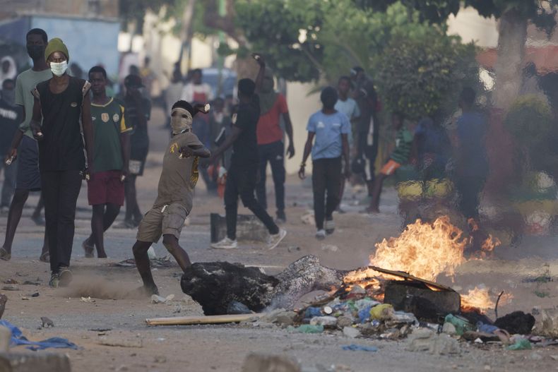Un manifestante lanza una piedra contra la policía durante un enfrentamiento en medio de una protesta en Dakar, Senegal, el sábado 3 de junio de 2023. (AP Foto/Leo Correa)