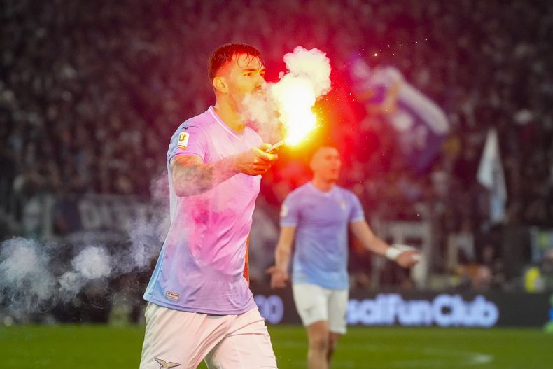Alessio Romagnoli de la Lazio sostiene una vengala que lanzaron al campo durante el encuentro de cuartos de final ante la Roma en la Copa de Italia el miércoles 10 de enero del 2024. (AP Foto/Gregorio Borgia)