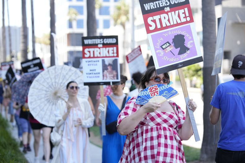 Manifestantes vestidos como personajes de Bridgerton con carteles fuera de los estudios de Netflix el martes, 18 de julio de 2023, en Los Ángeles. La huelga de actores se produce más de dos meses después de que los guionistas comenzaran se fueran a paro en su intento por obtener mejores salarios y condiciones laborales. (Foto AP/Chris Pizzello)