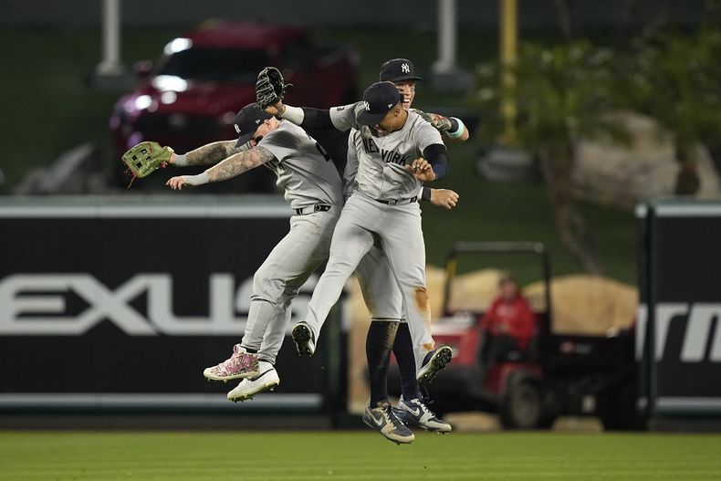 Alex Verdugo, a la izquierda, Juan Soto, centro, y Aaron Judge, de los Yankees de Nueva York, celebran después de que su equipo derrotó 2-1 a los Angelinos de Los Ángeles en un partido de béisbol el miércoles 29 de mayo de 2024, en Anaheim, California (AP Foto/Mark J. Terrill)