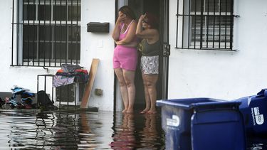 Dos mujeres reaccionan al ver su calle inundada, el jueves 13 de junio de 2024, en North Miami, Florida. (AP Foto/Marta Lavandier)