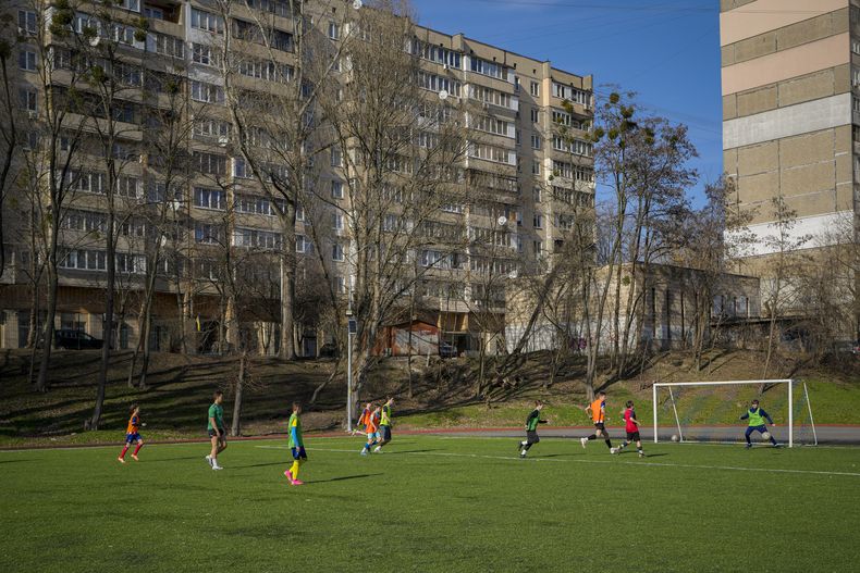 Un grupo de niños juega durante un entrenamiento de fútbol en Kiev, el miércoles 27 de marzo de 2024 (AP Foto/Vadim Ghirda)