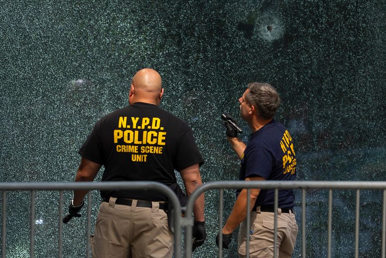 ARCHIVO - Agentes de la policía de Nueva York examinan una puerta con orificios de bala, el martes 29 de julio de 2025, un día después de un tiroteo. (AP Foto/Yuki Iwamura)