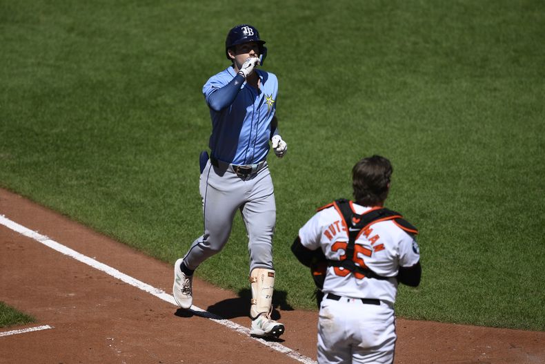 Jonny DeLuca (izquierda) de los Rays de Tampa Bay celebra frente al receptor de los Orioles de Baltimore, Adley Rutschman (derecha), luego de conectar un jonrón de dos carreras durante la sexta entrada del juego de béisbol el domingo 8 de septiembre de 2024, en Baltimore. (AP Foto/Nick Wass)