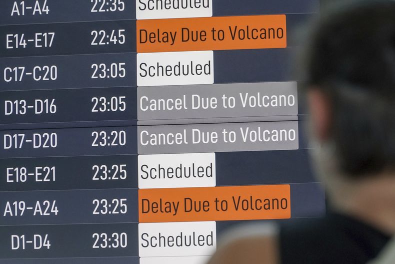 Un pasajero observa una pantalla en la que se informa de demoras de vuelos debido a la erupción del volcán Lewotobi Laki-Laki, en el aeropuerto internacional Ngurah Rai, en Badung, Bali, Indonesia, el 18 de junio de 2025. (AP Foto/Herdyanto)