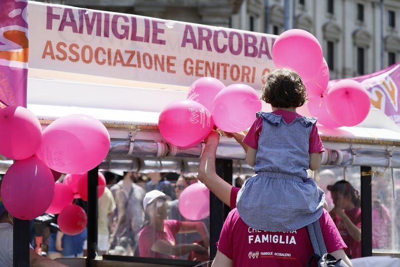 Gente participa del desfile Orgullo LGBTQ+ bajo una pancarta de la Asociación de Padres de Familia Arcoiris, en Roma, el sábado, 10 de junio de 2023. (Cecilia Fabiano/LaPresse via AP)