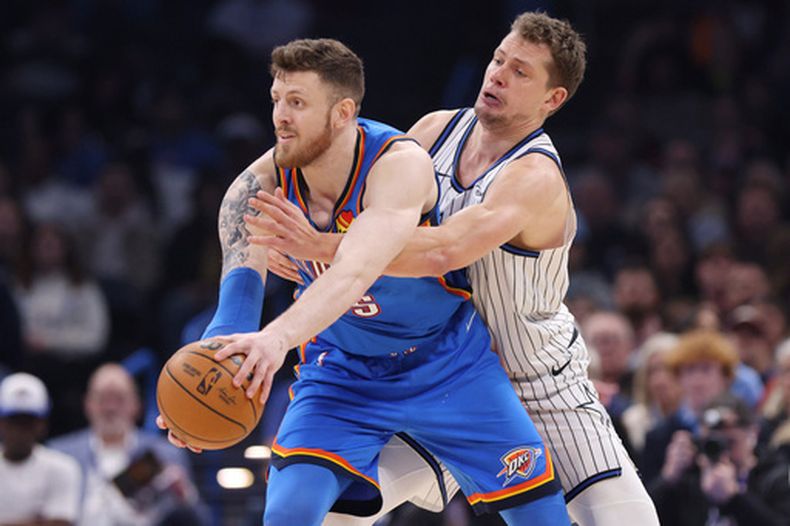 Isaiah Hartenstein, al frente, de los Thunder de Oklahoma City, protege el balón ante Moritz Wagner, de los Magic de Orlando, durante la primera mitad de un juego de baloncesto de la NBA el martes 3 de febrero de 2026, en Oklahoma City. (AP Photo/Nate Billings)
