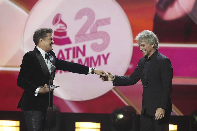 Carlos Vives y Jon Bon Jovi sonríen después de que Vives recibiera el premio a la Persona del Año de la Academia Latina de la Grabación en la 25a entrega del Latin Grammy el jueves 14 de noviembre de 2024, en Miami. (Foto AP/Lynne Sladky)