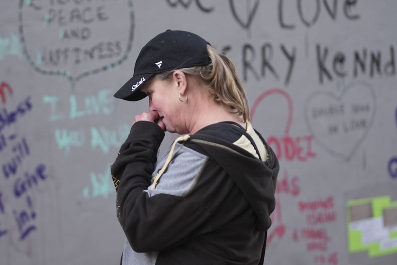 Alisa Kuhns, de visita desde Santa Rosa, California, reacciona en el altar improvisado en la calle Bourbon por las víctimas de un atropello ocurrido en Nochevieja en Nueva Orleans, el 3 de enero de 2025. (AP Foto/Gerald Herbert)