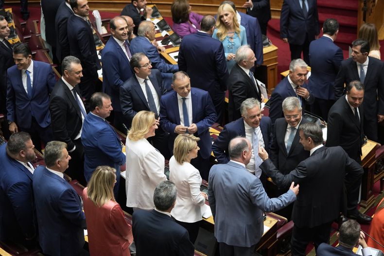 El primer ministro de Grecia, Kyriakos Mitsotakis, abajo a la derecha, habla con legisladores antes de la ceremonia de juramentación en el Parlamento en Atenas, Grecia, el lunes 3 de julio de 2023. (Foto AP/Thanassis Stavrakis)