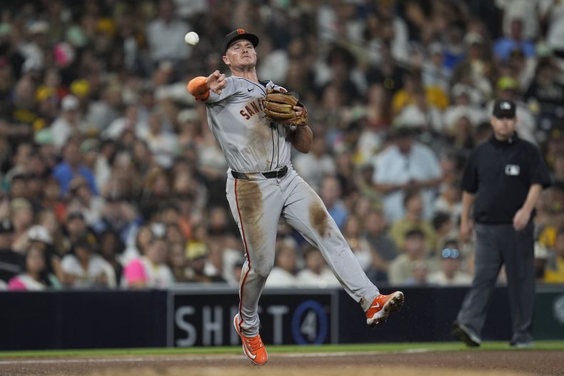 ARCHIVO - Matt Chapman, tercera base de los Gigantes de San Francisco, lanza a primera para retirar a Xander Bogaerts, de los Padres de San Diego, durante la sexta entrada del juego de béisbol, del 6 de septiembre de 2024, en San Diego. (AP Foto/Gregory Bull, File)