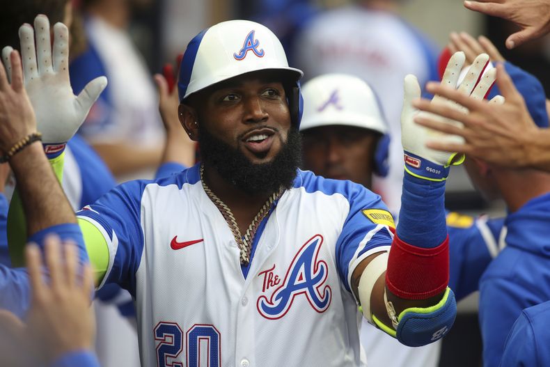 El bateador designado de los Bravos de Atlanta, Marcell Ozuna (20), celebra con sus compañeros de equipo después de un jonrón de dos carreras en la primera entrada contra los Filis de Filadelfia, el sábado 6 de julio de 2024, en Atlanta. (AP Foto/Brett Davis)