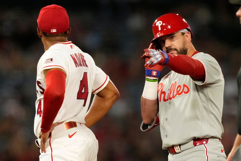 Kyle Schwarber de los Filis de Filadelfia hace un gesto tras batear un doble remolcador ante el segunda base de los Angelinos de Los Ángeles Christian Moore en la décima entrada el sábado 29 de agosto del 2026. (AP Foto/Mark J. Terrill)